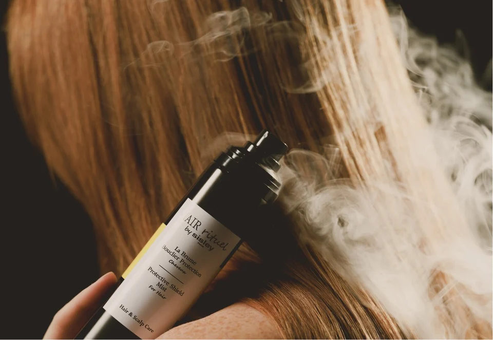 Model from behind holding Hair Rituel Protective Shield Mist