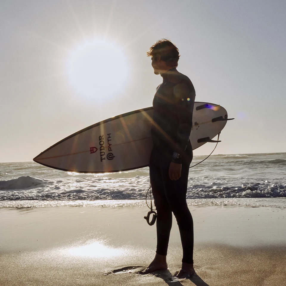 Nic Von Rupp looking at the ocean with his surfboard