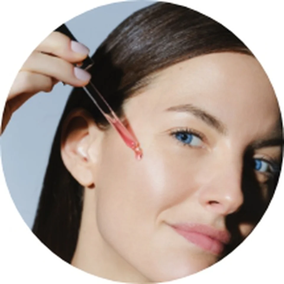 Woman applying Black Rose Concentrate serum