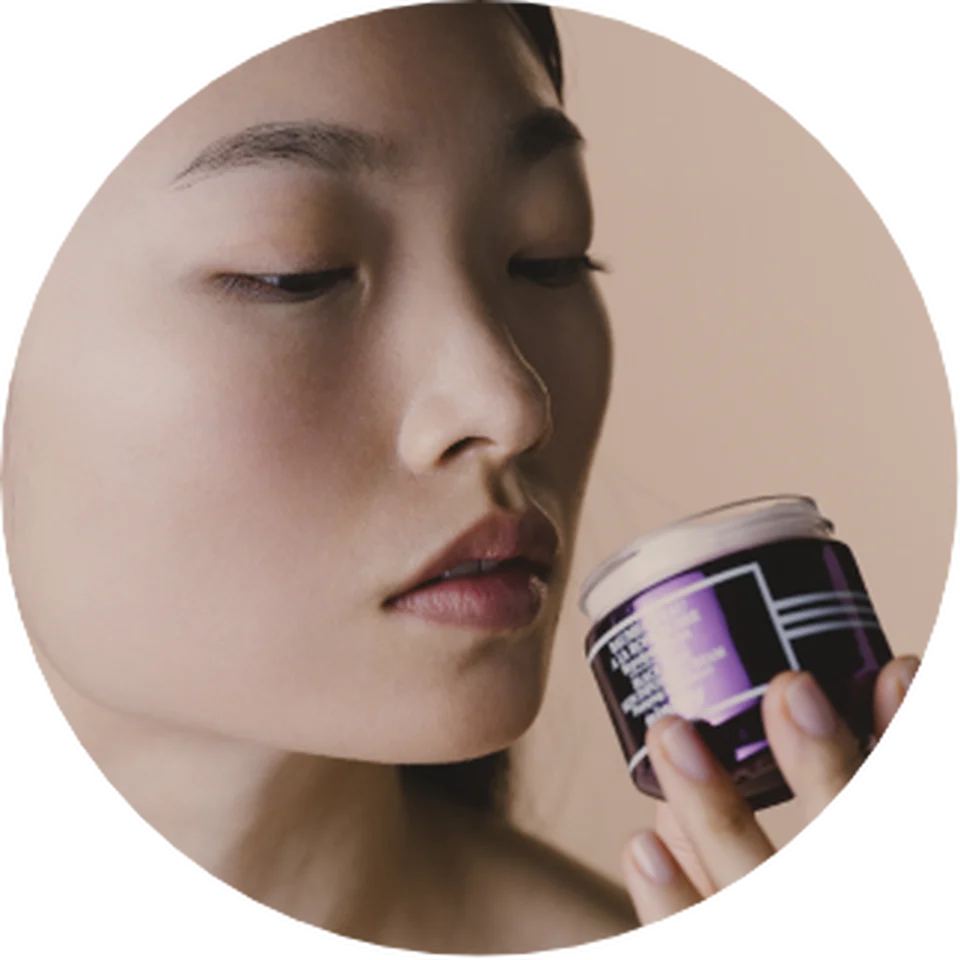 Woman looking at Black Rose Skin Infusion Cream