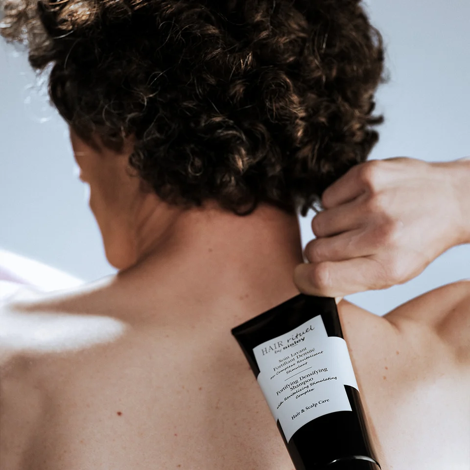 Man holding the Fortifying Densifying Shampoo